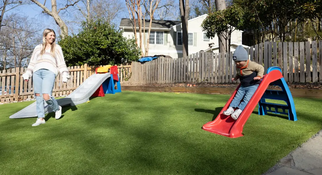 family playing on artificial grass lawn