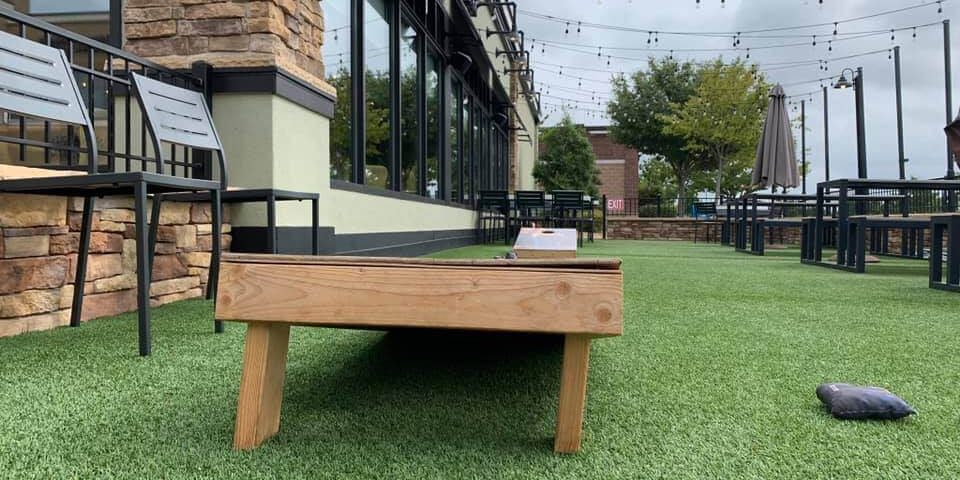 Cornhole game set up on commercial artificial grass